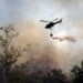 Fire fighting helicopter dropping water onto wildfire