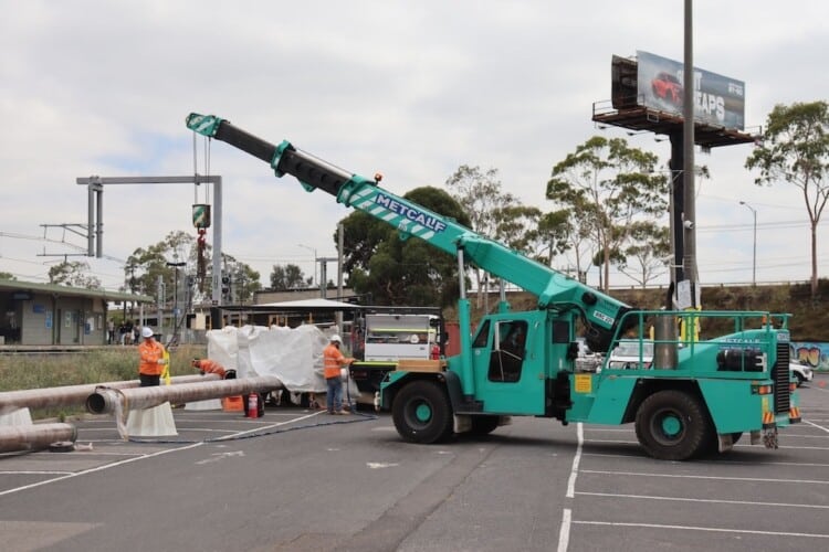 Crane lifting jet fuel pipes on site at Albion Station